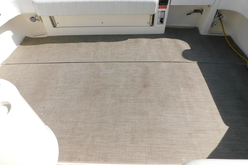 Slide: The Image of 1997 Sea Ray 330 Express Cruiser deck with beige carpet and white seating. - 27