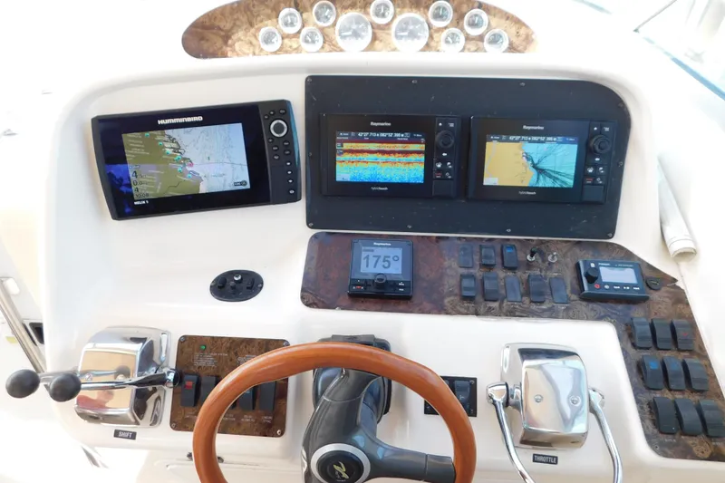 Slide: The Image of Control panel of a 1997 Sea Ray 330 Express Cruiser with navigation displays and steering wheel. - 32