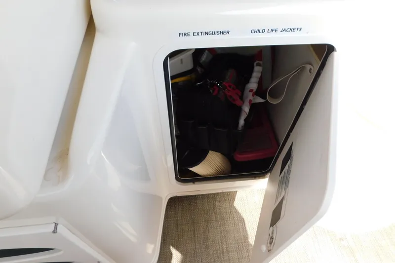 Slide: The Image of Storage compartment on a 1997 Sea Ray 330 Express Cruiser, labeled for fire extinguisher and child life jackets. - 21