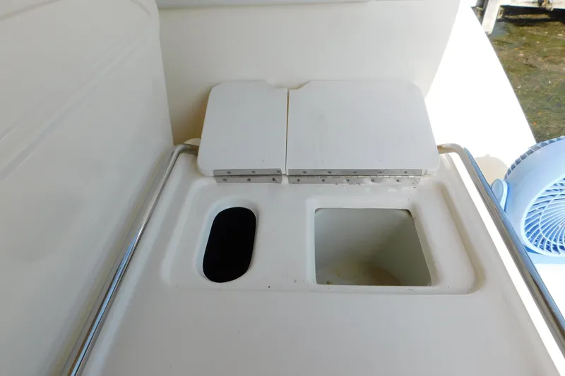 Slide: The Image of 1997 Sea Ray 330 Express Cruiser sink area with storage compartments and fan. - 23
