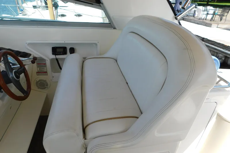 Slide: The Image of 1997 Sea Ray 330 Express Cruiser cockpit with white seating and steering wheel. - 26