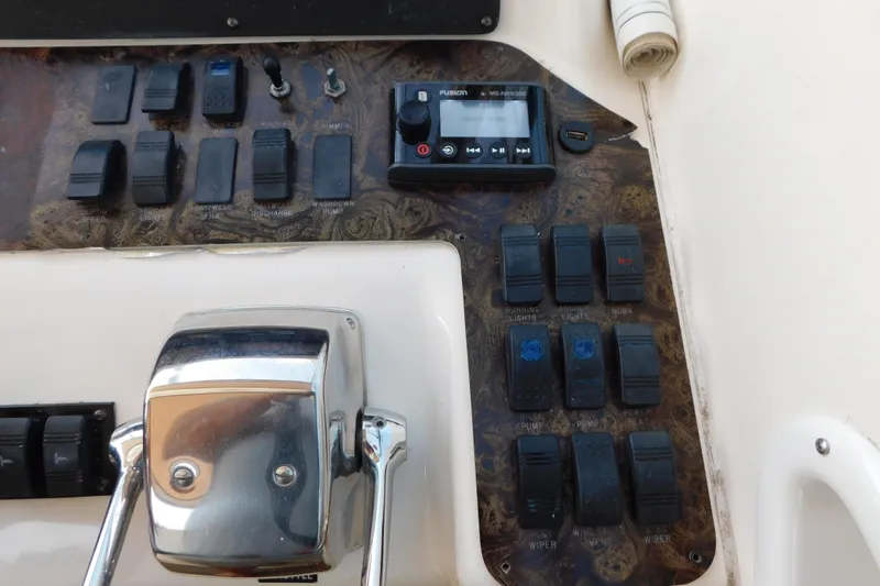 Slide: The Image of Control panel of a 1997 Sea Ray 330 Express Cruiser with switches and a Fusion stereo. - 34