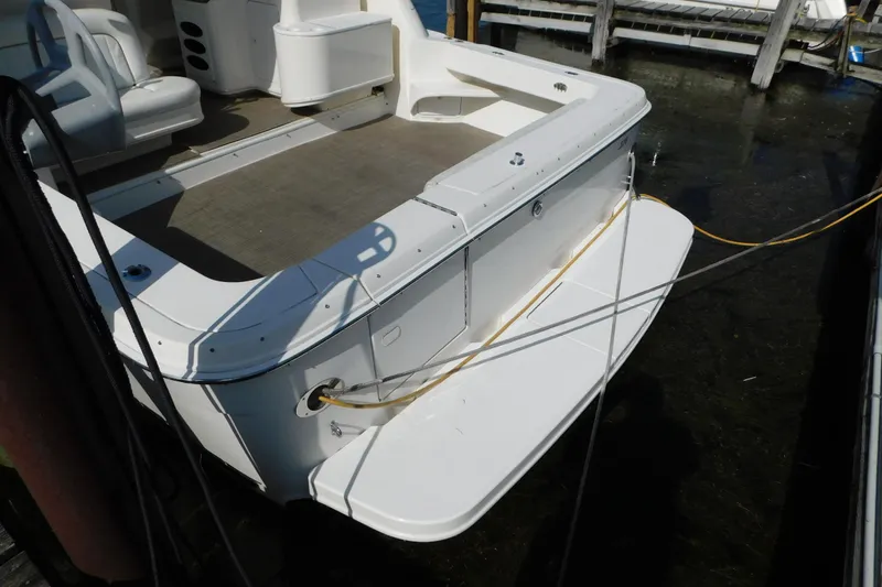Slide: The Image of 1997 Sea Ray 330 Express Cruiser docked, showcasing spacious deck and seating area. - 6