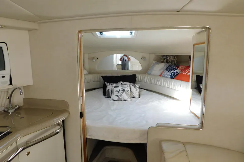 Slide: The Image of Interior of 1997 Sea Ray 330 Express Cruiser with cozy bed and kitchenette. - 49