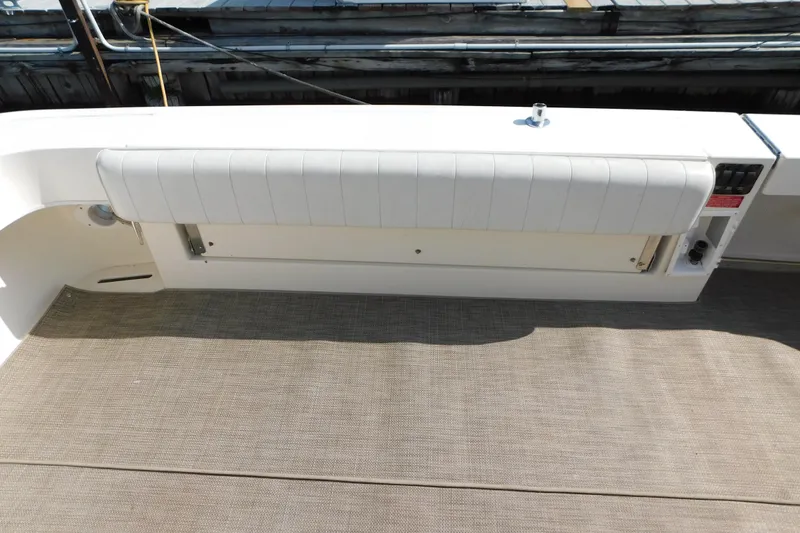 Slide: The Image of 1997 Sea Ray 330 Express Cruiser interior with cushioned seating and carpeted flooring. - 14