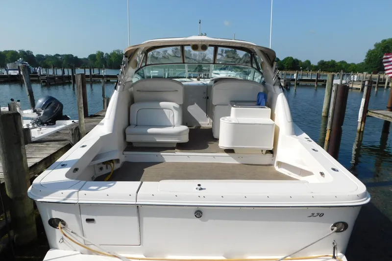 Slide: The Image of 1997 Sea Ray 330 Express Cruiser docked at marina, showcasing spacious deck and seating. - 5