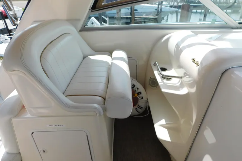Slide: The Image of 1997 Sea Ray 330 Express Cruiser interior with white seating and control panel. - 38