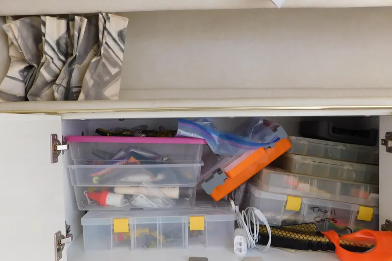 Slide: The Image of Storage cabinet on a 1997 Sea Ray 330 Express Cruiser with organized fishing gear and tackle boxes. - 57
