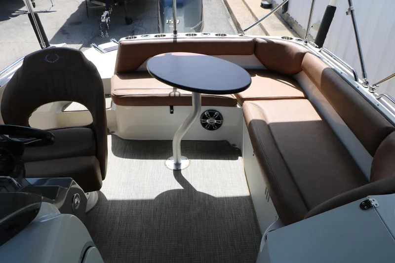 Slide: The Image of 2022 Stingray 192 SC boat interior with brown seating and a central table. - 38