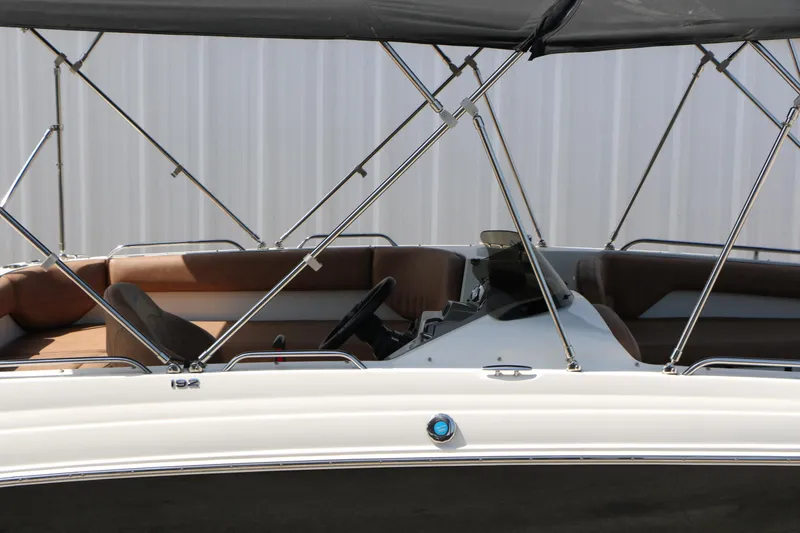 Slide: The Image of 2022 Stingray 192 SC boat interior with brown seating and canopy. - 14