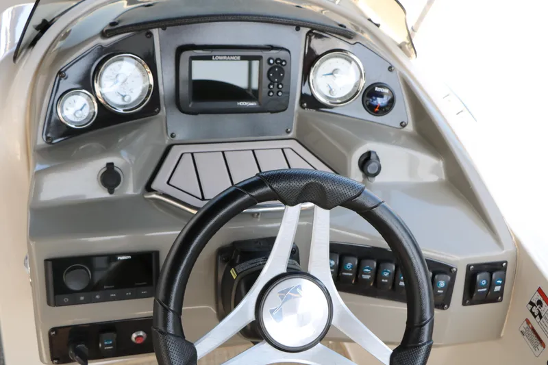 Slide: The Image of 2022 Stingray 192 SC boat dashboard with steering wheel, gauges, and control panel. - 34