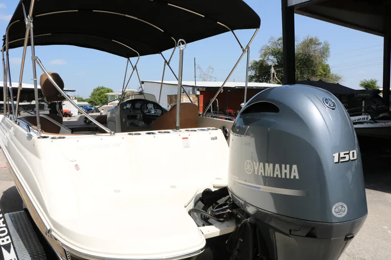 Slide: The Image of 2022 Stingray 192 SC boat with Yamaha 150 engine, parked outdoors under a canopy. - 9