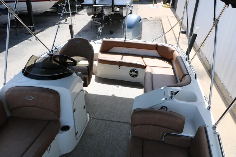 Slide: The Image of 2022 Stingray 192 SC boat interior with brown seating and steering console. - 28