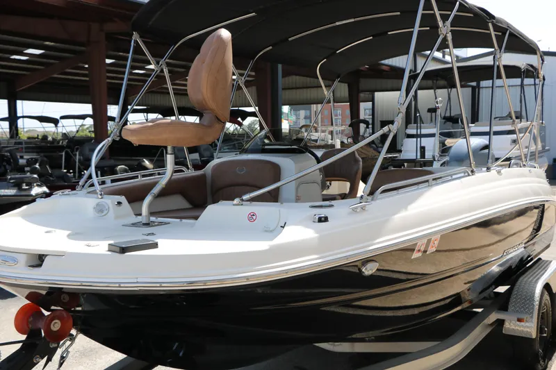 Slide: The Image of 2022 Stingray 192 SC boat with canopy, displayed in a showroom setting. - 19