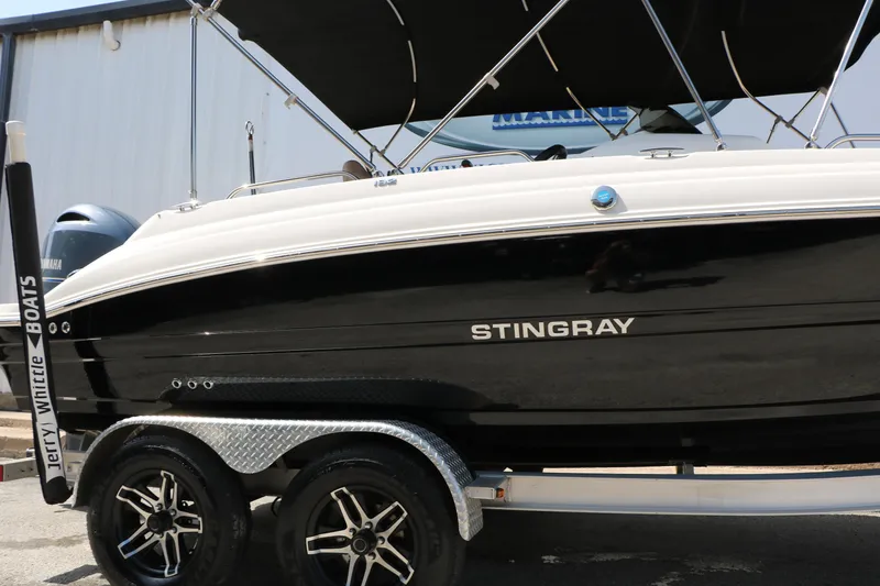 Slide: The Image of 2022 Stingray 192 SC boat on trailer, black and white design, parked outdoors. - 16