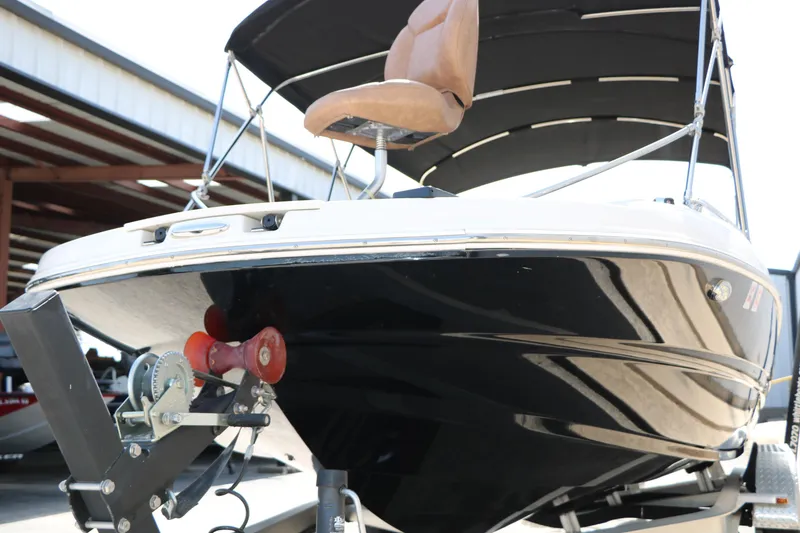 Slide: The Image of 2022 Stingray 192 SC boat on trailer, featuring sleek black hull and canopy. - 18