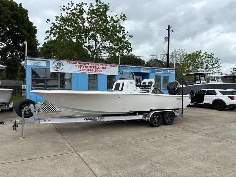 The Image of A Tidewater 2500 Carolina Bay boat on a trailer in front of a blue building. - 1