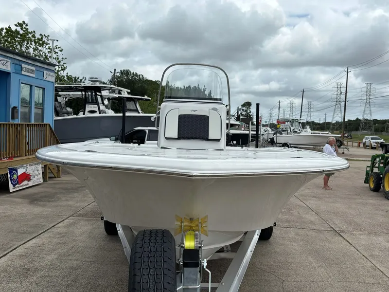 Slide: The Image of A Tidewater 2500 Carolina Bay boat on a trailer, surrounded by other boats and buildings. - 13
