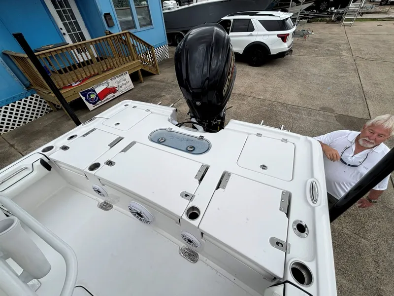 Slide: The Image of A white boat with multiple storage compartments and an outboard motor. A man stands beside it. - 11