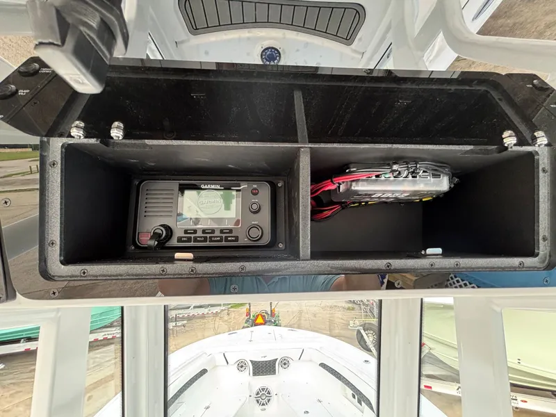 Slide: The Image of The image shows an open storage compartment with a Garmin radio and cables on a boat. - 11