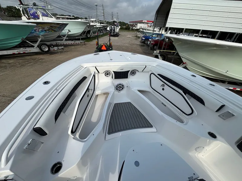 Slide: The Image of The image shows the bow of a Tidewater 272 Center Console Adventure boat. It's in a lot with other boats. - 7