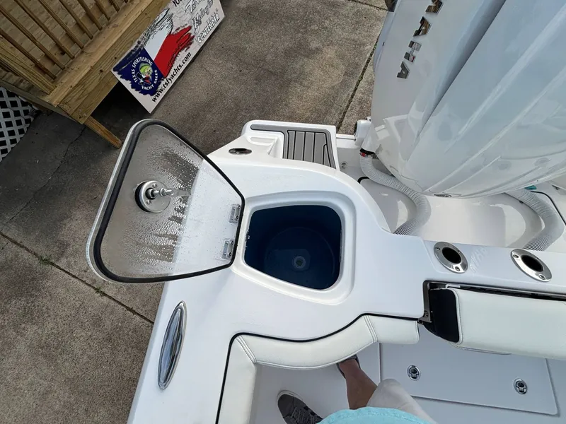 Slide: The Image of An open storage compartment on a boat with a white deck and engine. - 24