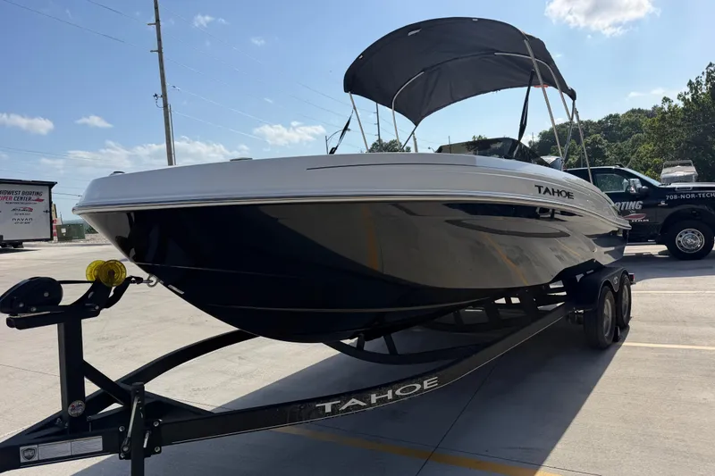 Slide: The Image of 2024 Tahoe T21 boat on trailer, parked outdoors under clear sky. - 8