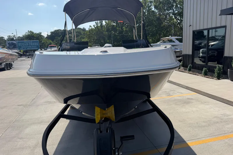 Slide: The Image of 2024 Tahoe T21 boat on trailer, parked outdoors near dealership. - 9