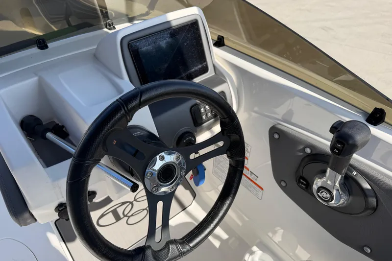 Slide: The Image of 2024 Tahoe T21 boat dashboard with steering wheel and control panel. - 20