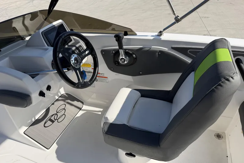 Slide: The Image of 2024 Tahoe T21 boat cockpit with steering wheel and cushioned seat. - 12