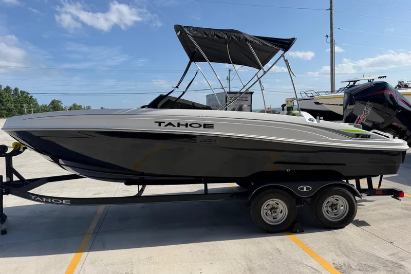 Slide: The Image of 2024 Tahoe T21 boat on trailer, sleek design, black and white color scheme, sunny day. - 7