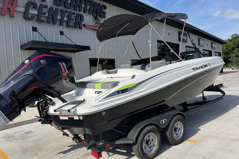 Slide: The Image of 2024 Tahoe T21 boat on trailer outside boating center, featuring sleek design and powerful engine. - 3