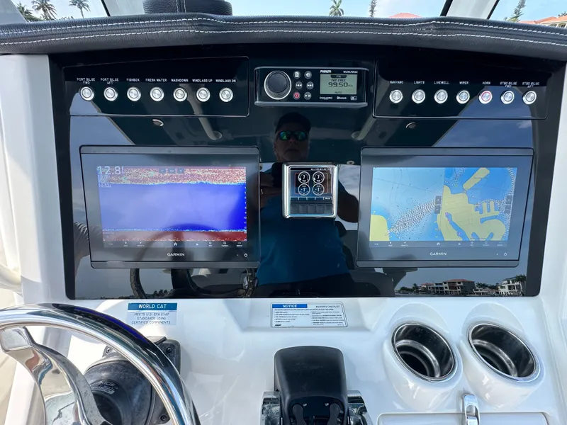 Slide: The Image of Dashboard of a World Cat 280 CC-X with two Garmin screens and controls. - 49