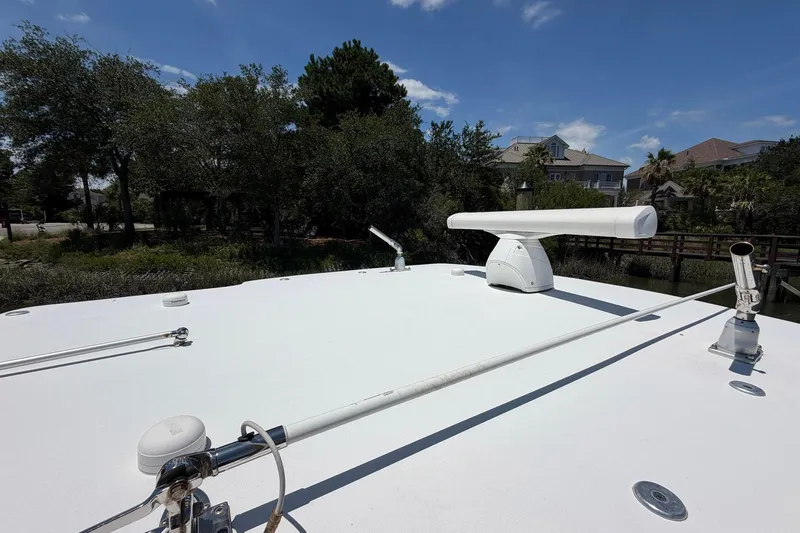 Slide: The Image of 2016 Edgewater 368CC boat roof with radar and antennas, surrounded by trees and houses. - 68