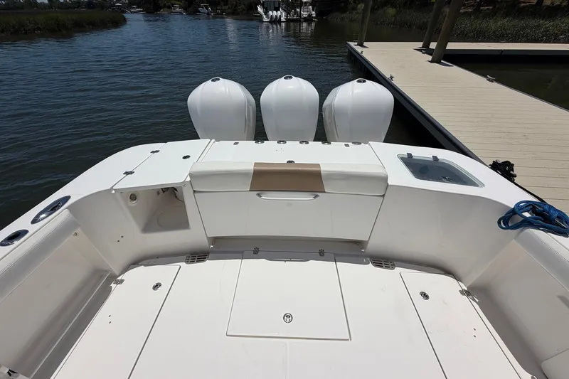 Slide: The Image of 2016 Edgewater 368CC boat with triple outboard engines docked by a pier. - 17