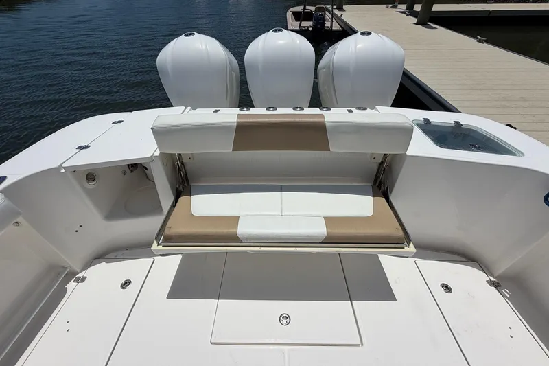 Slide: The Image of 2016 Edgewater 368CC boat with triple engines and cushioned seating at the dock. - 18