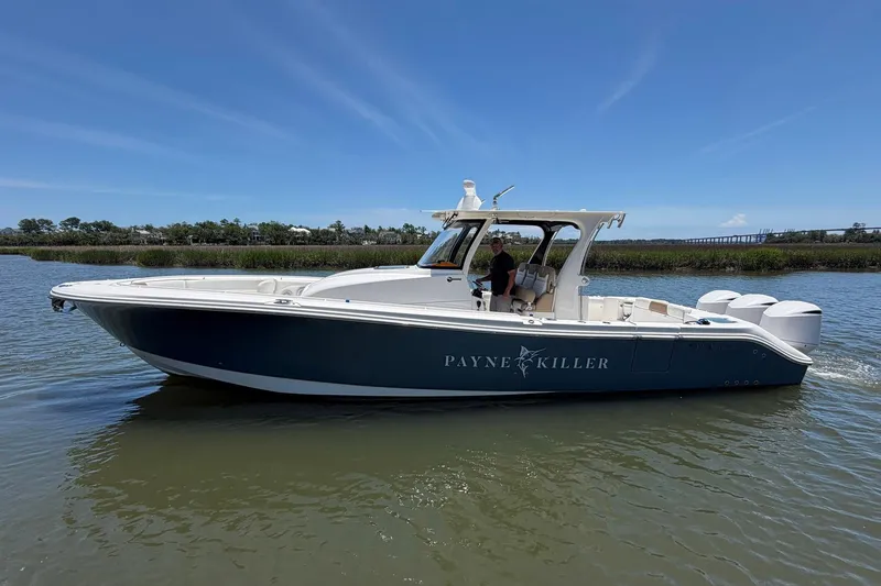 The Image of 2016 Edgewater 368CC boat on calm water, featuring sleek design and triple engines. - 1