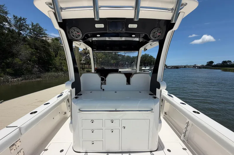 Slide: The Image of 2016 Edgewater 368CC boat interior with seating and storage, docked by a scenic waterway. - 22
