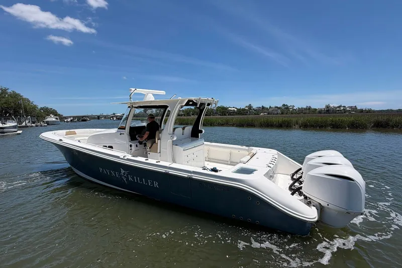 Slide: The Image of 2016 Edgewater 368CC boat cruising on a sunny day with triple outboard engines. - 7