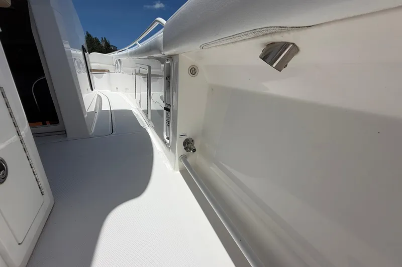 Slide: The Image of 2016 Edgewater 368CC boat interior, showcasing sleek white deck and storage compartments. - 29