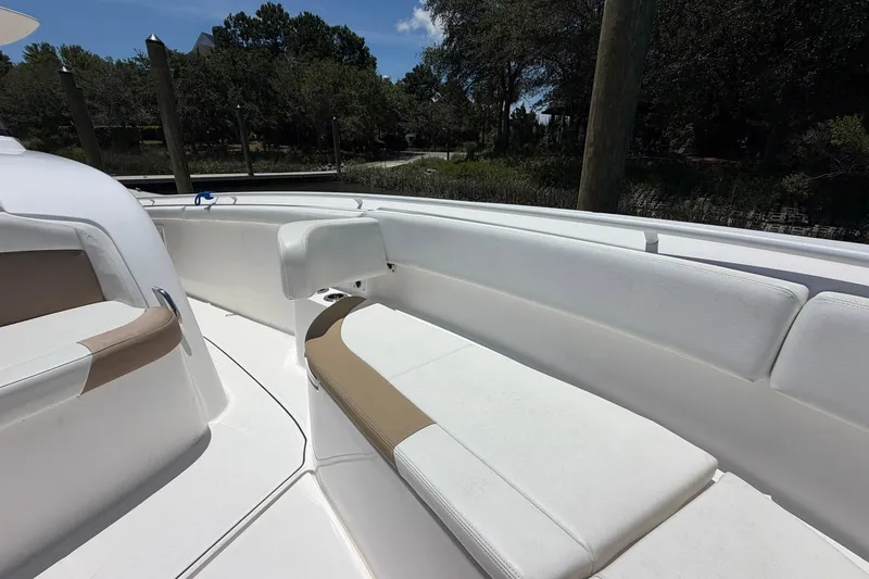 Slide: The Image of 2016 Edgewater 368CC boat interior with white and beige seating, docked outdoors. - 33