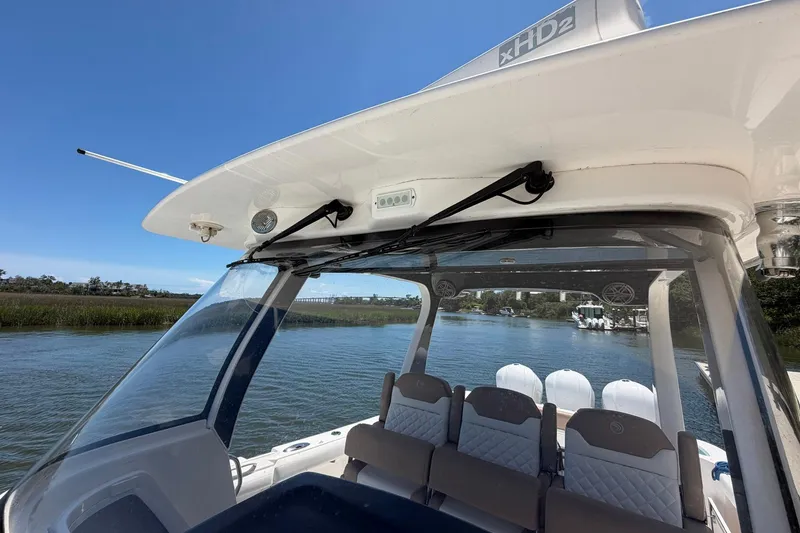 Slide: The Image of 2016 Edgewater 368CC boat interior with seating, windshield, and waterway view. - 39