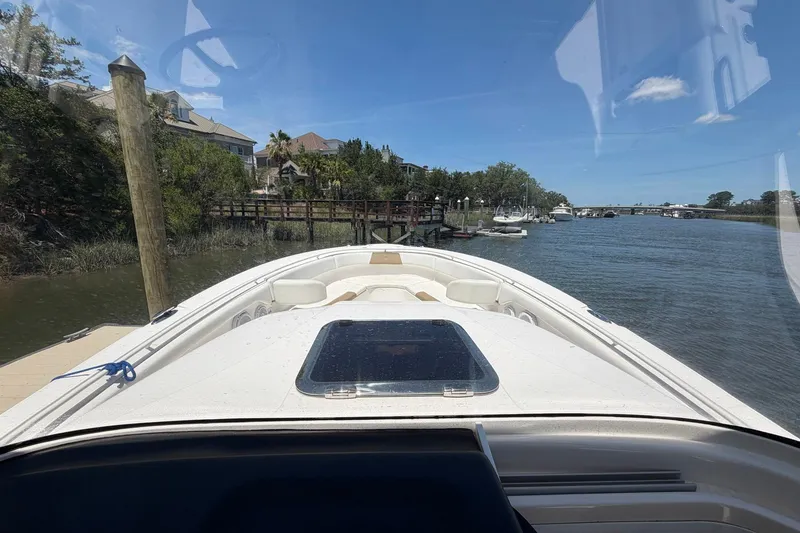 Slide: The Image of 2016 Edgewater 368CC boat docked by a scenic riverside with clear blue skies. - 40