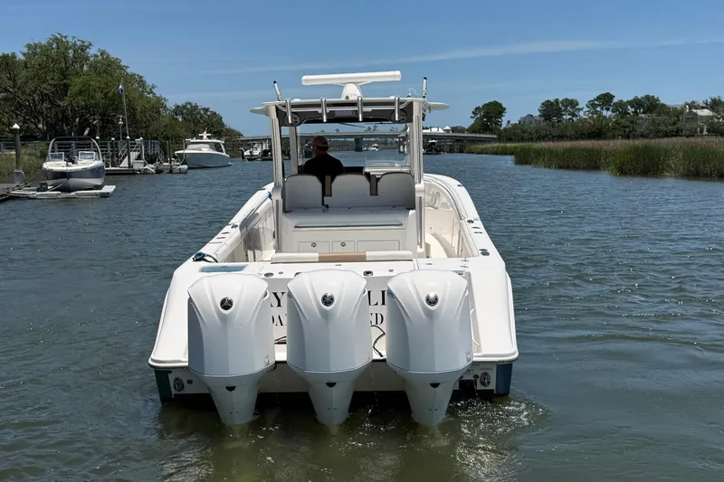 Slide: The Image of 2016 Edgewater 368CC boat with triple engines cruising on a calm river. - 9