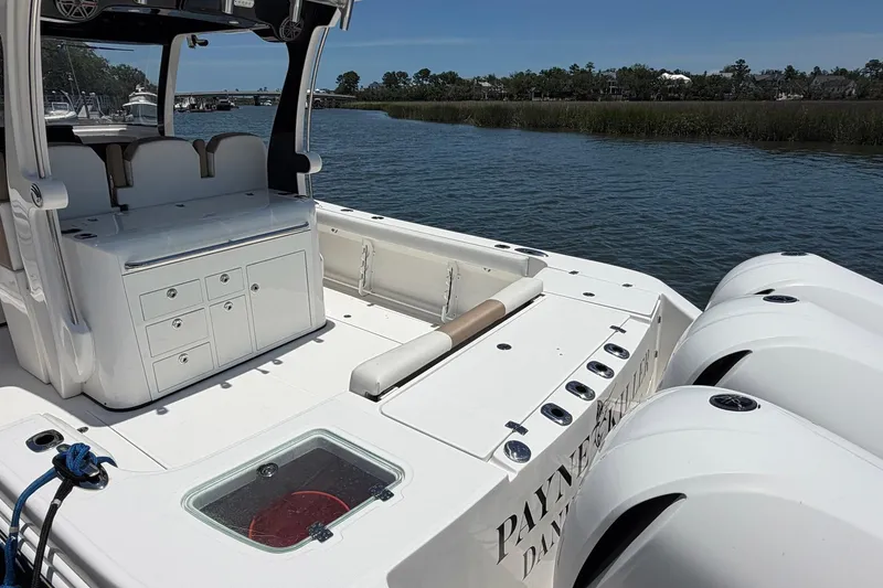 Slide: The Image of 2016 Edgewater 368CC boat with triple engines, docked on a calm river. - 19