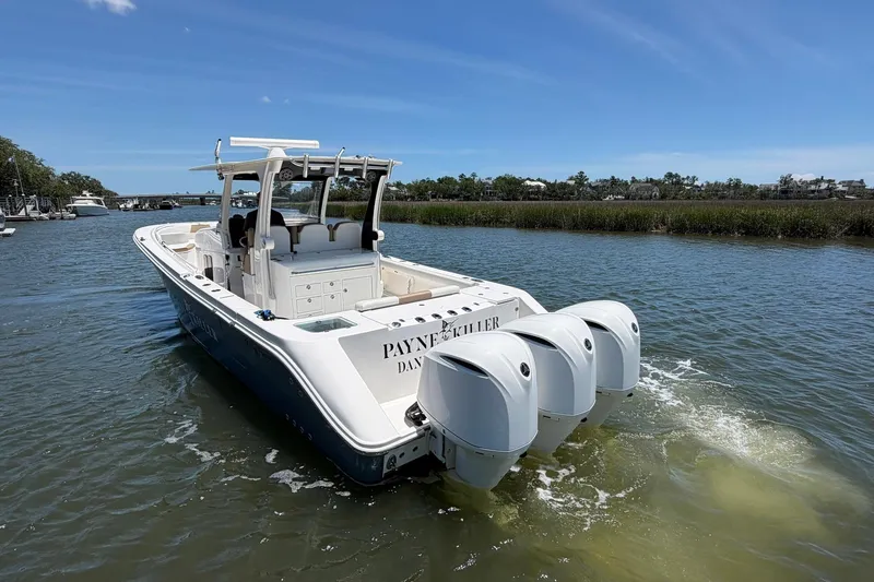 Slide: The Image of 2016 Edgewater 368CC boat with triple engines cruising on a sunny day. - 8