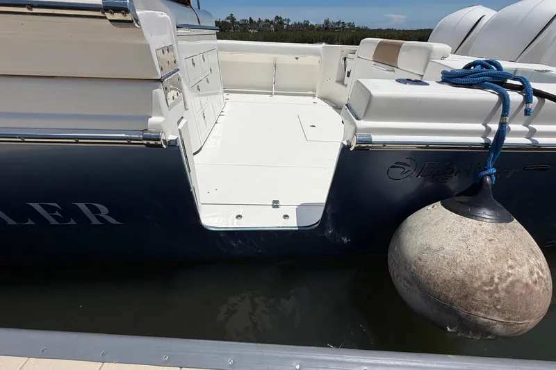 Slide: The Image of 2016 Edgewater 368CC boat docked, featuring open deck and mooring buoy. - 73