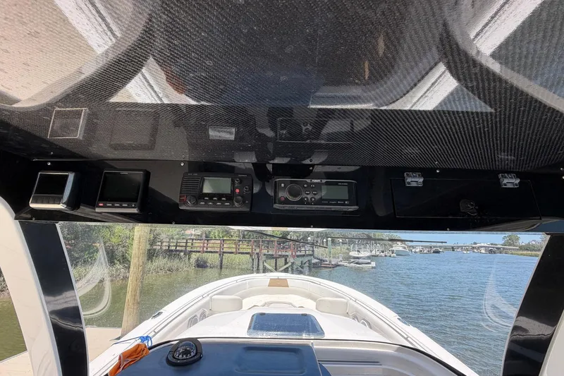 Slide: The Image of 2016 Edgewater 368CC boat dashboard with electronic controls and scenic marina view. - 54