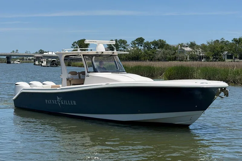 Slide: The Image of 2016 Edgewater 368CC boat on calm water, featuring sleek design and Garmin equipment. - 11