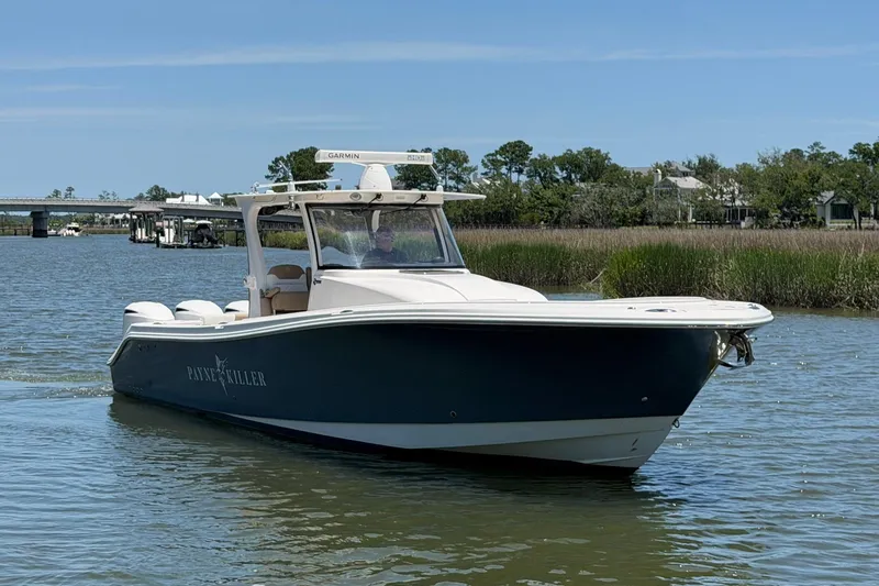 Slide: The Image of 2016 Edgewater 368CC boat cruising on a calm river with scenic background. - 12